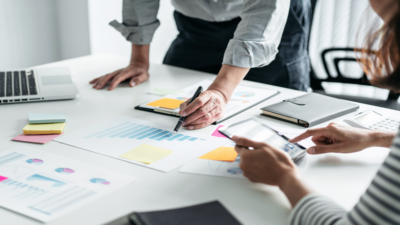 Two people reviewing software project performance data to support software vendor negotiations