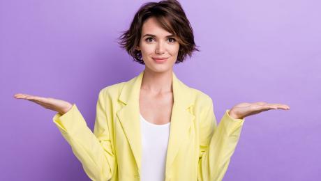 Young woman holding out her hands to her side to indicate asking a question.