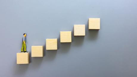 Figurine of a man climbing wooden block steps