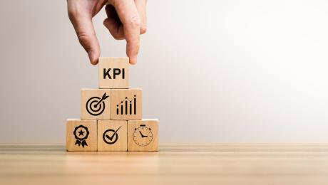 Male hand stacking wooden block representing software project Key Process Indicators